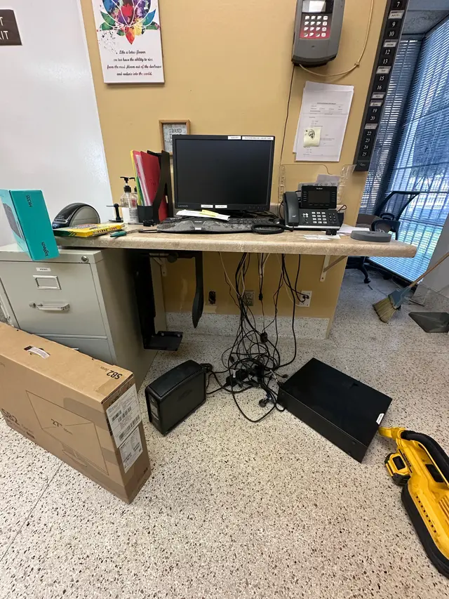 Before: desk buried in loose cables and equipment