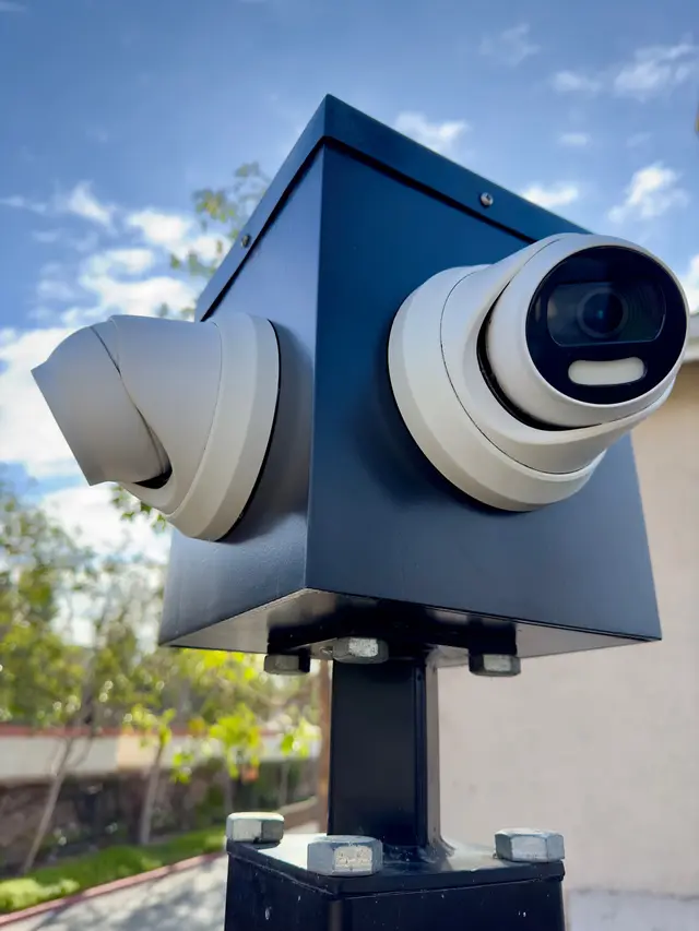 Two turret security cameras covering opposite angles from one mount