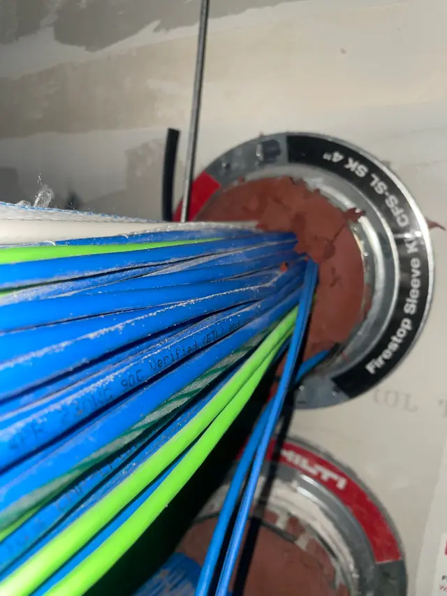 Cat6 cable bundle passing through a fire-rated firestop sleeve