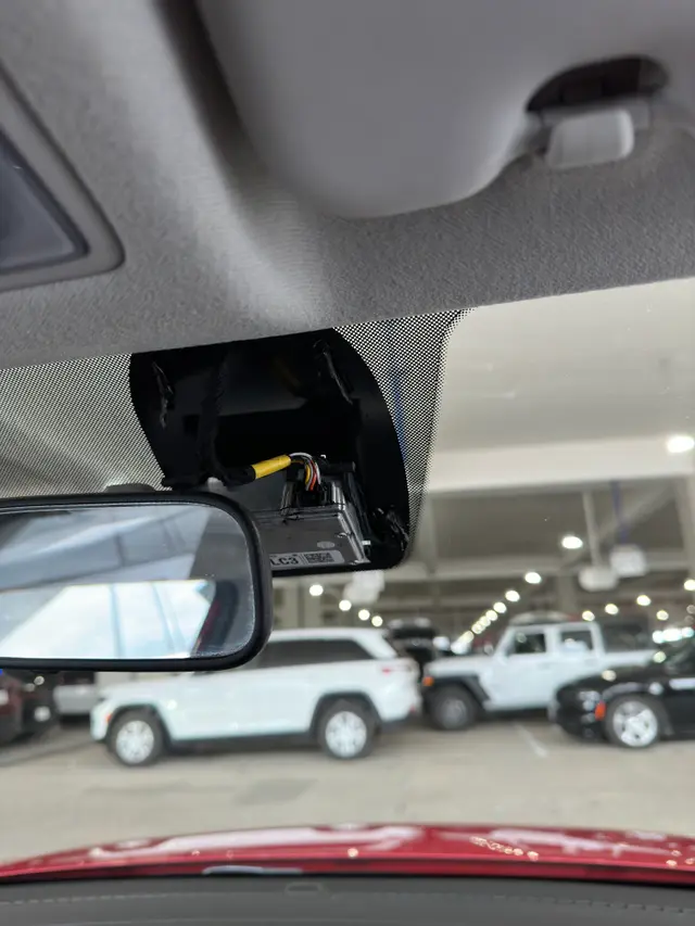 Fleet dash camera installed behind a truck rearview mirror