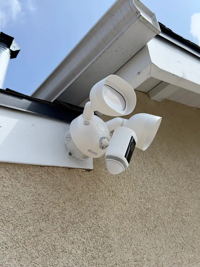 Floodlight security camera installed at a residential corner