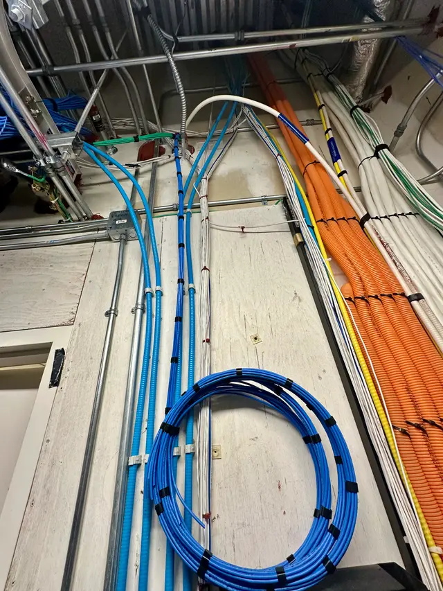 Color-coded low-voltage cable runs routed along a ceiling