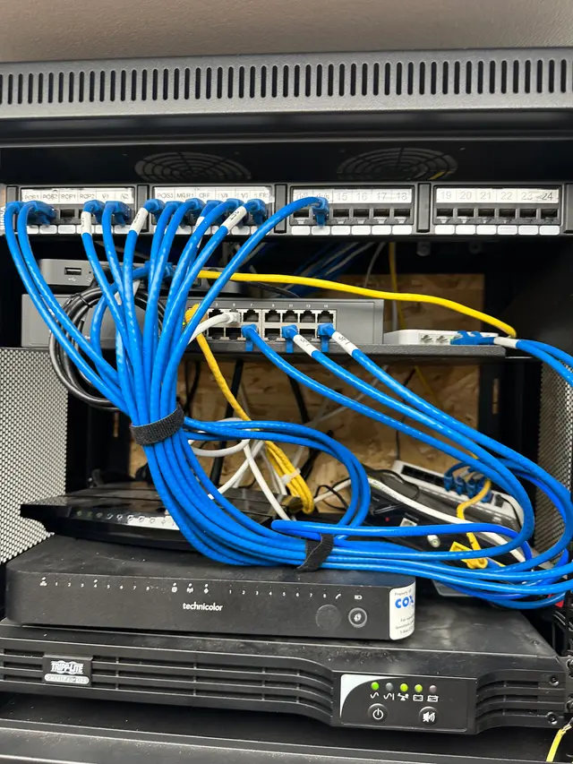 Before: tangled network cables piled on a plywood backboard