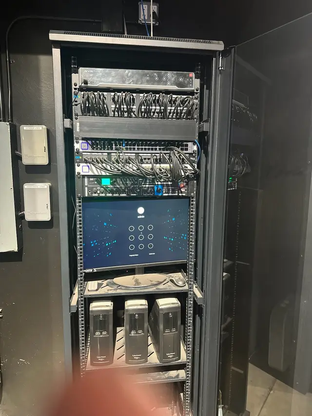 Full-height network rack with switches, patch panels and monitoring display installed by CoreConnectIT