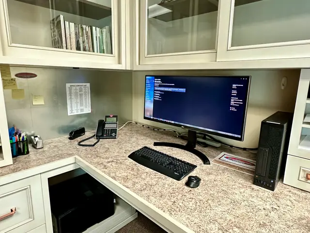 Office desk with monitor and VoIP desk phone installed
