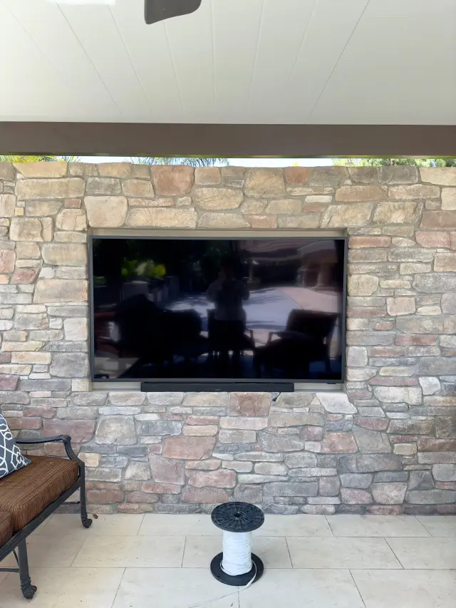 Outdoor television and soundbar installation for backyard entertainment space