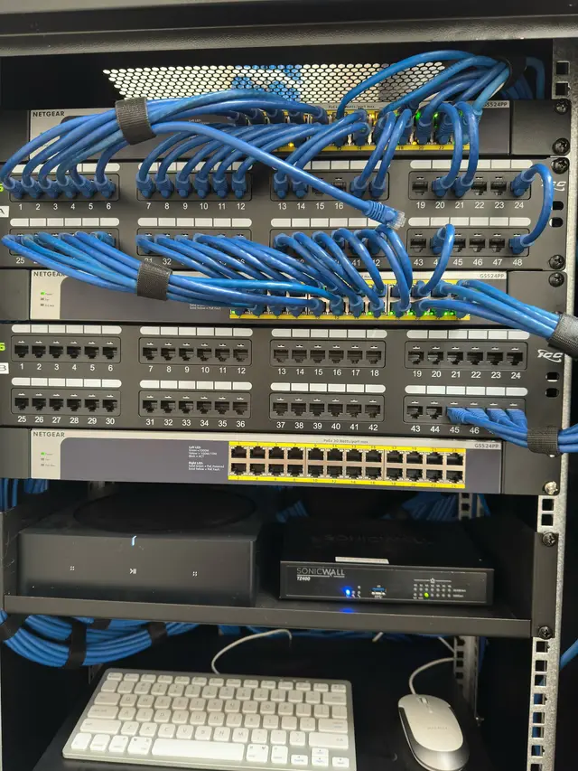 Patch panel and PoE switch with dressed blue Cat6 cabling