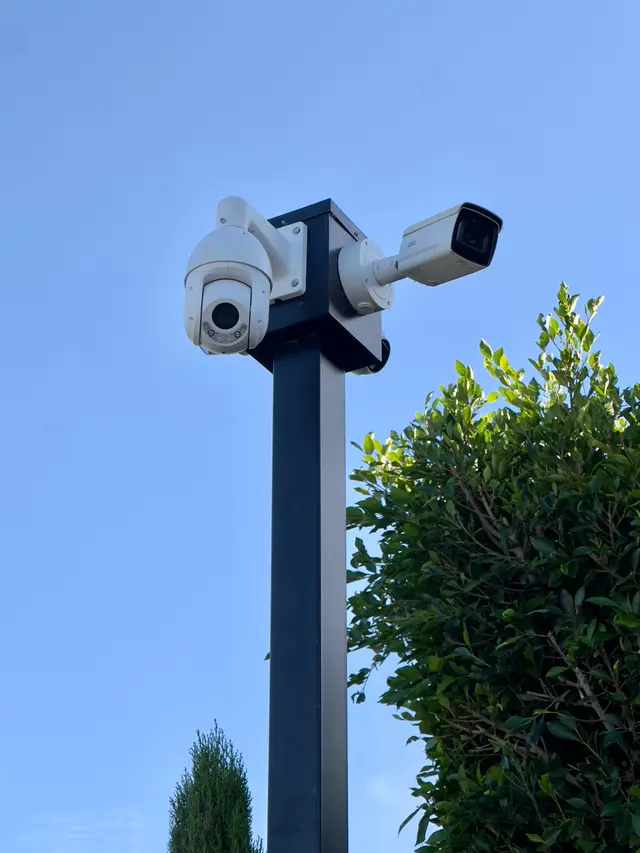 White PTZ and bullet security cameras installed on a pole by CoreConnectIT