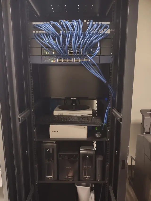 Network rack with dressed blue Cat6 cabling and rack-mounted monitor