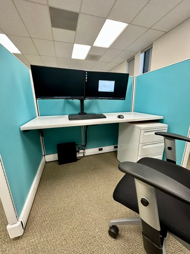 Stacked dual monitor mount installed at an office cubicle