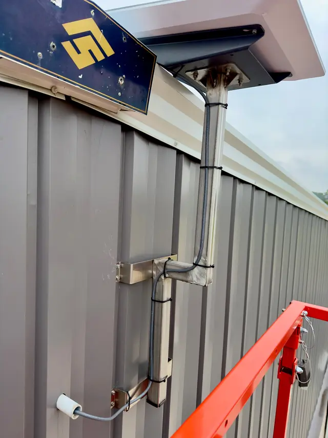 Starlink mount and conduit installed along a metal building roofline