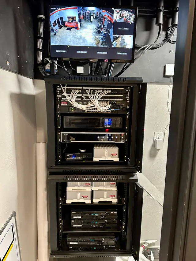 Wall-mounted network rack with patch panel, switch and firewall installed