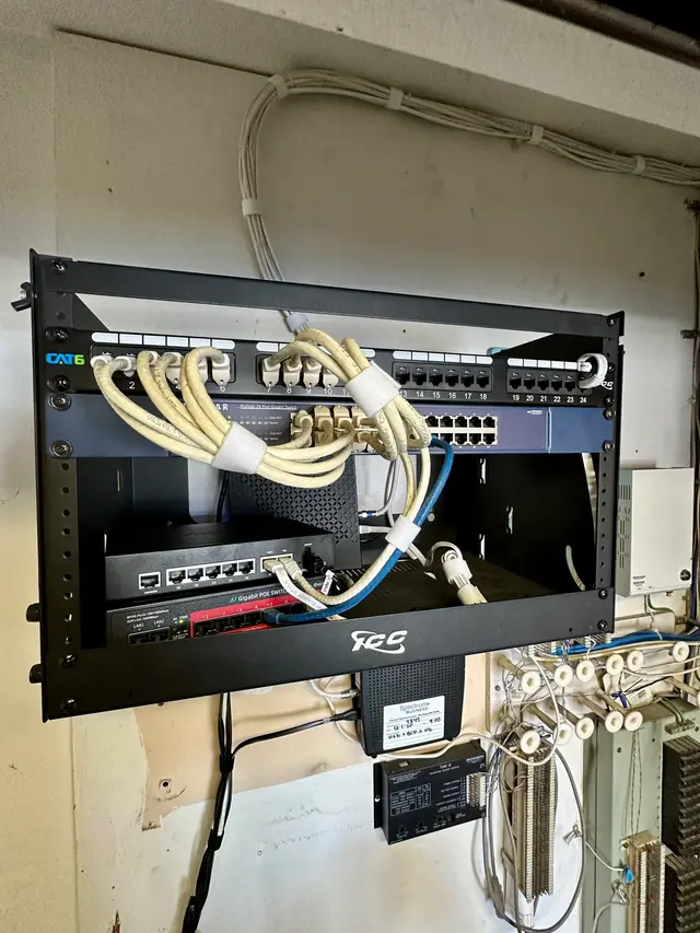 Wall-mounted rack with network switch and neatly combed patch cables